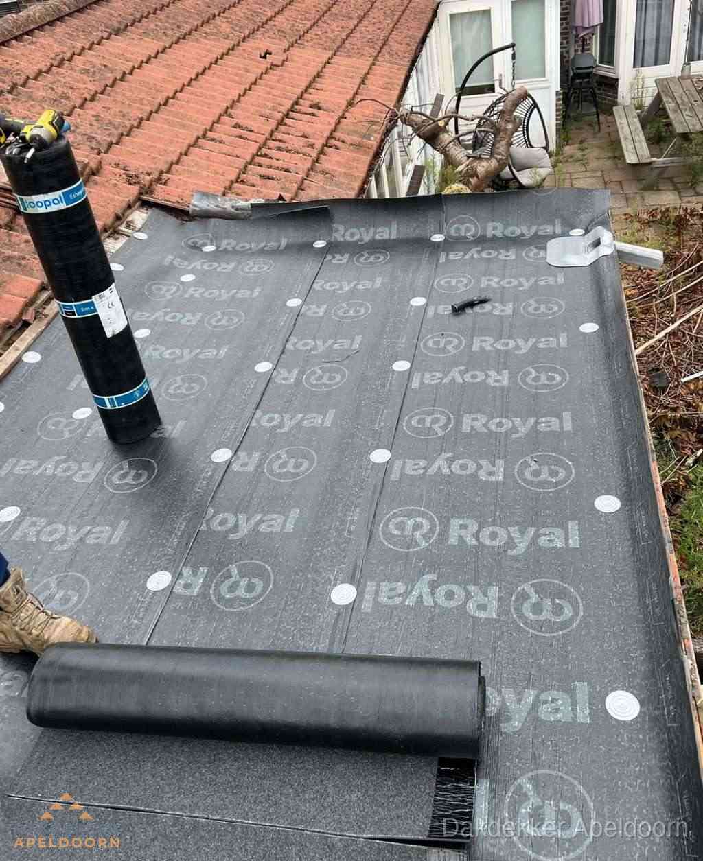Plat dak met nieuwe bitumen dakbedekking en brandgereedschap in Apeldoorn