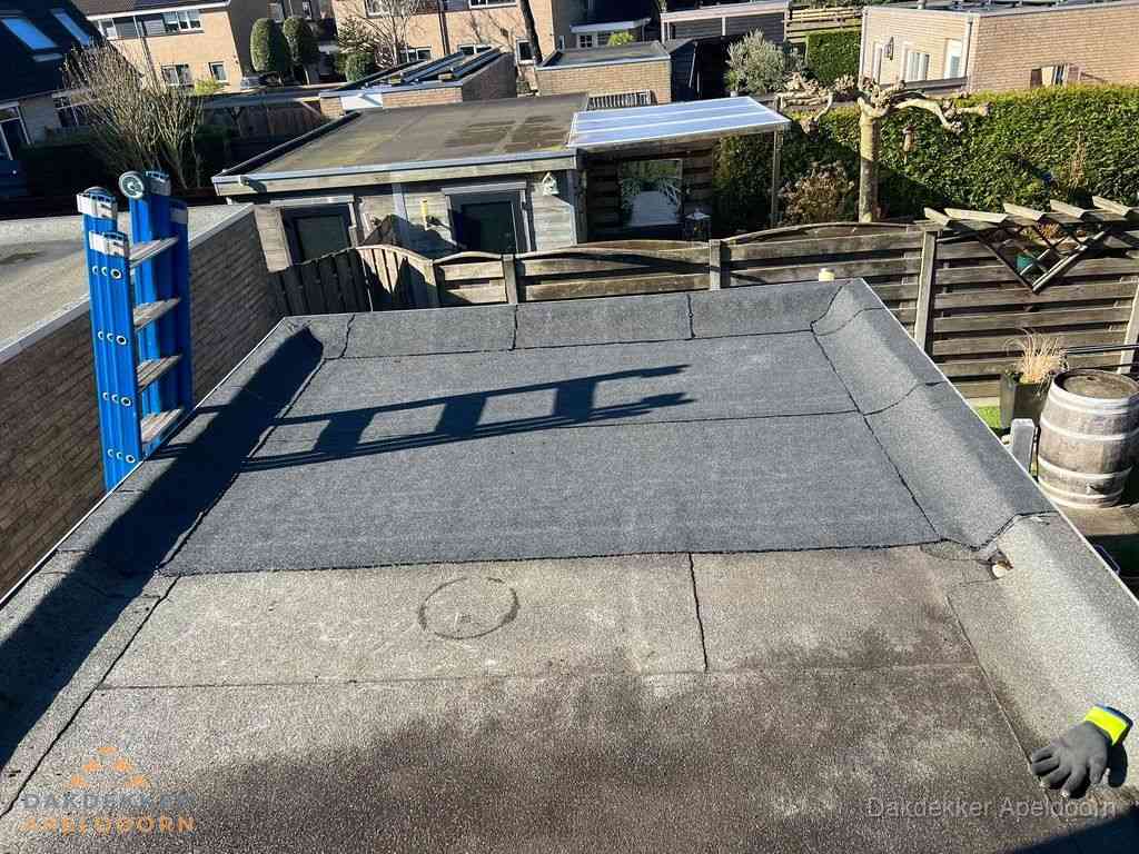 Dakdekker legt onderlaag op plat dak met houten constructie in Apeldoorn