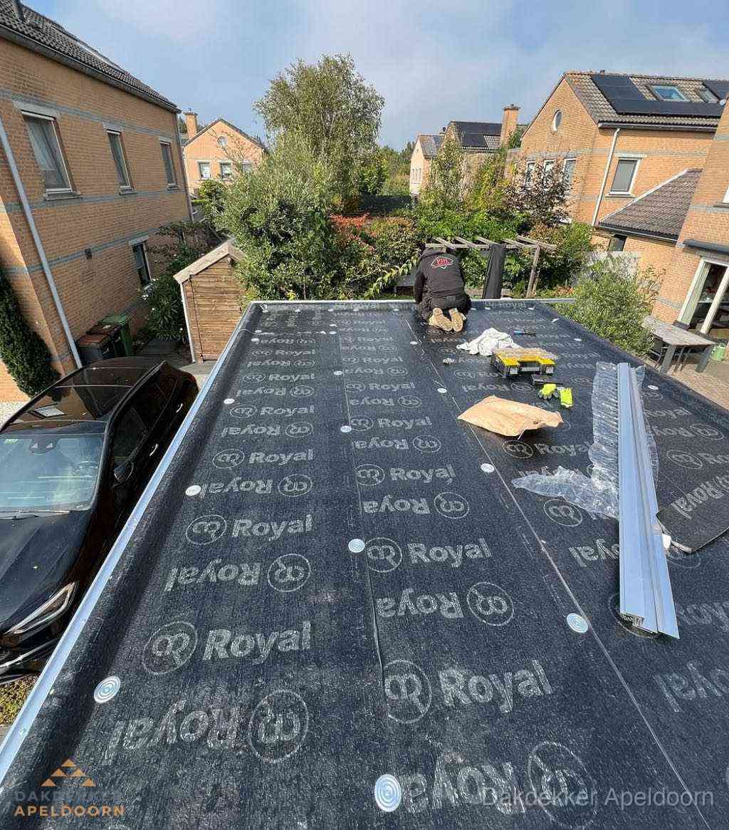 Dakdekker aan het werk op plat dak renovatie in Apeldoorn
