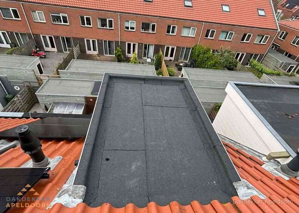 Plat dak met bitumen bedekking naast dakkapel in Apeldoorn