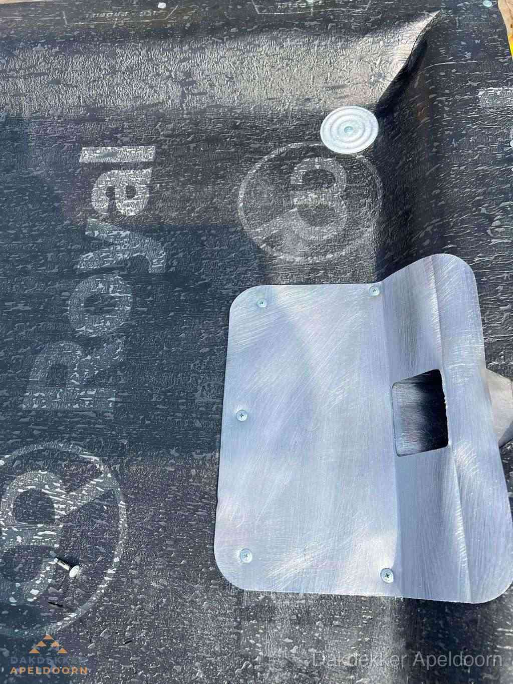 Dakdoorvoer met metalen afvoerplaat op bitumen dak in Apeldoorn