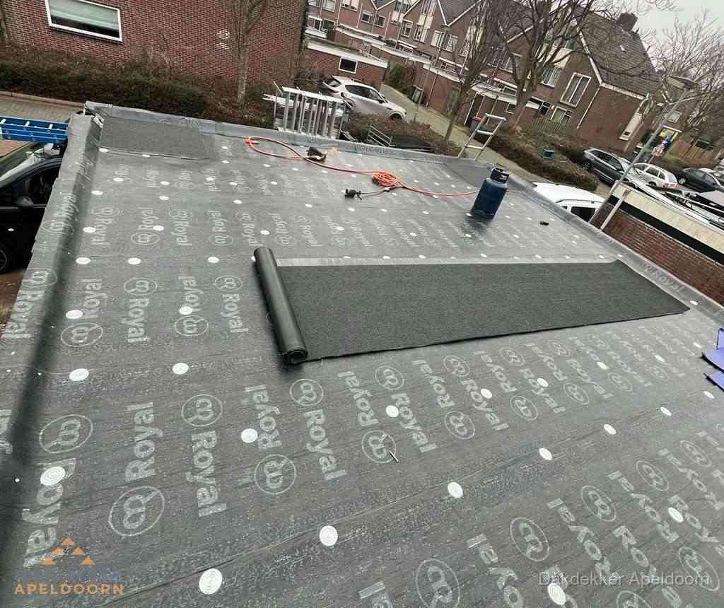 Dakdekker aan het werk met gasbrander op plat bitumen dak in Apeldoorn