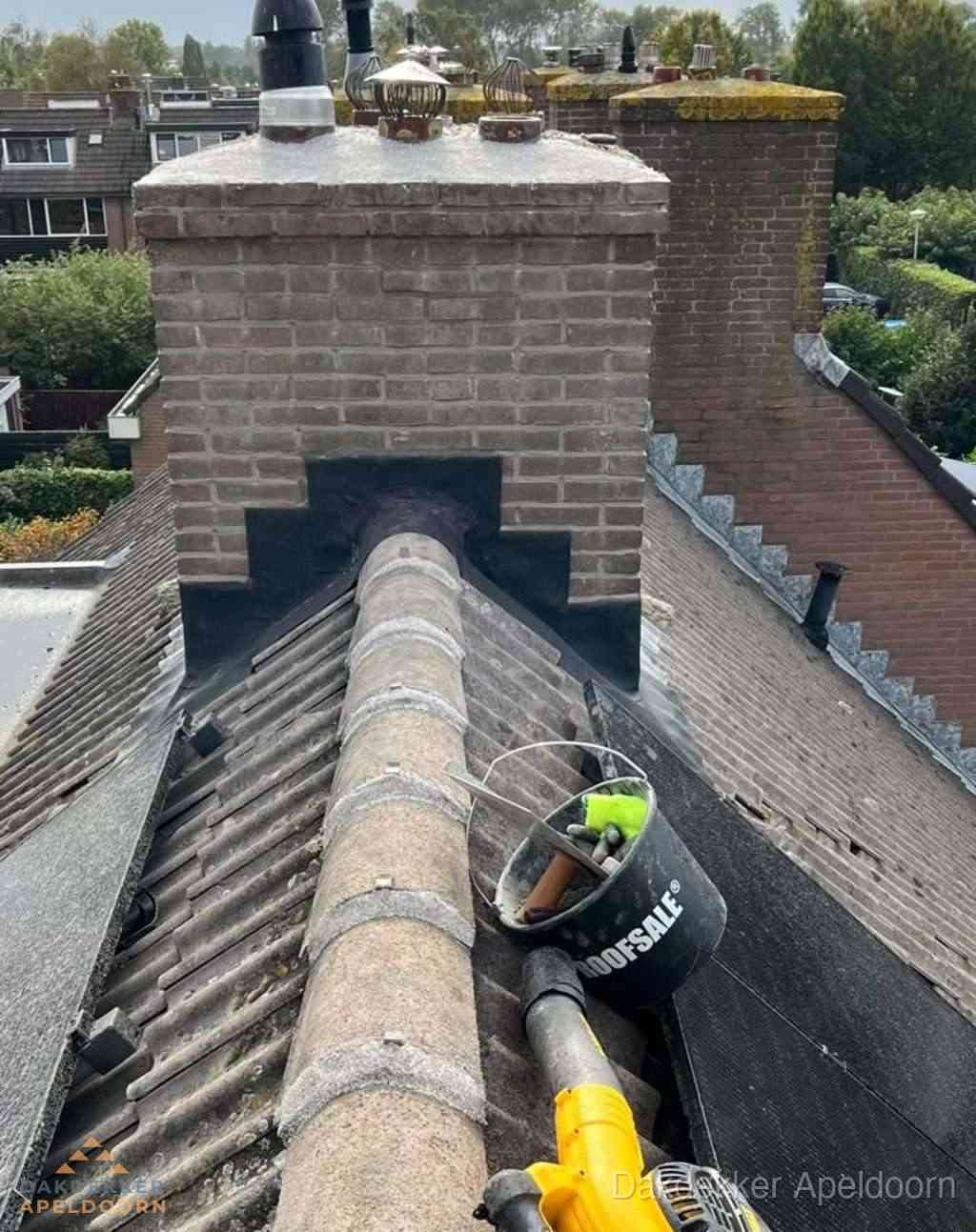 Dakdekker repareert bitumen dakleer bij dakdoorvoer in Apeldoorn
